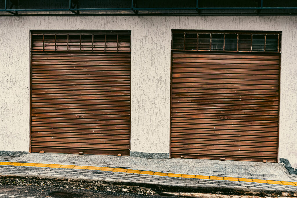 Worn Commercial Garage Doors on an industrial building showing signs of aging and damage